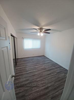 Long Beach apartment for rent - an empty living room with a ceiling fan and a window
