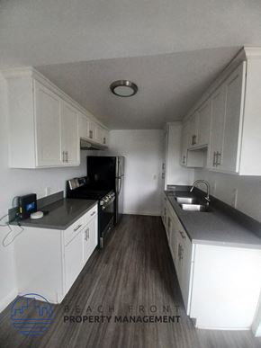 Los Angeles apartment for rent - a small kitchen with white cabinets and a sink and a stove