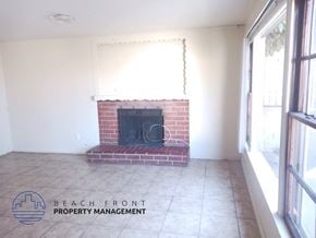 Redondo Beach triplex for rent - an empty living room with a brick fireplace and a tiled floor