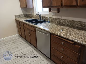 Downey apartment for rent - a kitchen with a granite counter top and a dishwasher