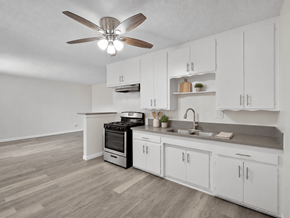 Long Beach apartment for rent - A kitchen with white cabinets and a wood floor.