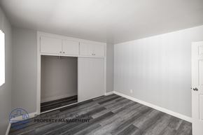 Long Beach apartment for rent - A room with a large window, a built-in cabinet, and a wooden floor.