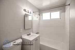 Long Beach apartment for rent - A white bathroom with a sink, mirror, and bathtub.