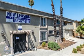 Long Beach apartment for rent - A building with a sign that says "NOW LEASING" and a phone number.