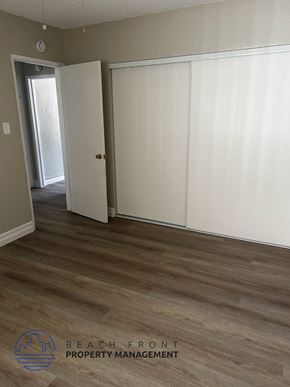 Garden Grove apartment for rent - A room with a white door and a white closet with a logo of Beach Front Property Management.