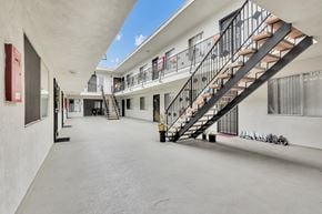 Hawthorne apartment for rent - A long black metal staircase with a black railing leads to a balcony.