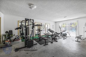 Hawthorne apartment for rent - A gym with a variety of equipment including a weight bench, a squat rack, and a treadmill.