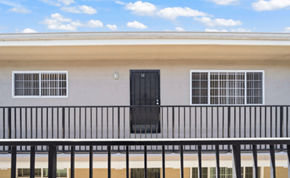 Long Beach apartment for rent - A building with a black door and windows with white bars.