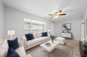 Long Beach apartment for rent - A living room with a white couch, a coffee table, and a ceiling fan.