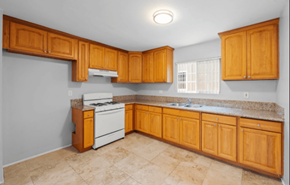 Long Beach apartment for rent - A kitchen with wooden cabinets and a white stove top oven.
