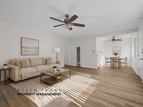 Downey apartment for rent - A living room with a couch, a coffee table, and a ceiling fan.