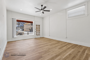 Long Beach apartment for rent - A spacious room with wooden flooring and a ceiling fan.