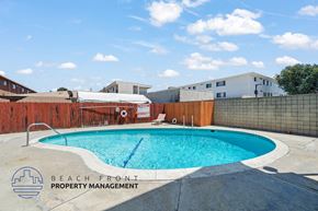 Hawthorne apartment for rent - A pool surrounded by a fence with the words Beach Front Property Management on it.
