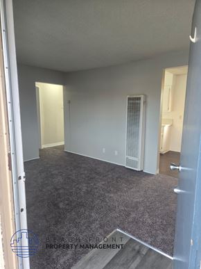 Norwalk apartment for rent - A room with a carpeted floor and a door on the right side.