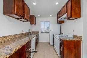 Long Beach apartment for rent - A kitchen with wooden cabinets and a granite countertop.
