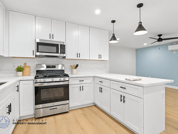 Long Beach apartment for rent - A kitchen with white cabinets and a stainless steel stove.