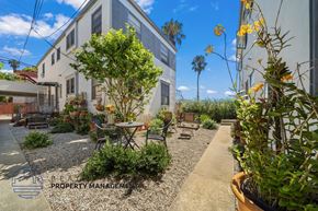 Santa Monica apartment for rent - a courtyard with tables and chairs in front of a building