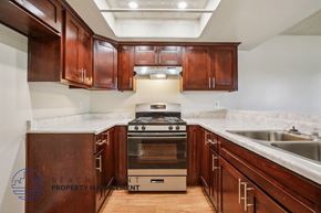 Santa Ana apartment for rent - A kitchen with wooden cabinets and a stove top oven.
