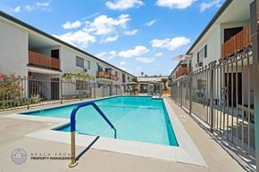 Downey apartment for rent - A swimming pool in a residential area with a blue metal handrail.