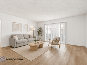 Gardena apartment for rent - A living room with a grey couch, a wooden coffee table, and a chair.