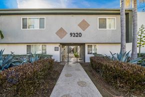 Downey apartment for rent - The image shows a building with the number 9320 on it, surrounded by greenery and a clear sky.