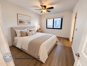 Los Angeles apartment for rent - A bedroom with a bed, a ceiling fan, and a painting on the wall.