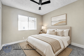 Wilmington apartment for rent - A well-lit bedroom with a large bed and a ceiling fan.