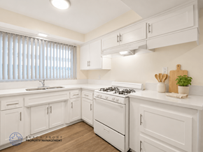 Inglewood apartment for rent - A kitchen with white cabinets and a white stove top oven.