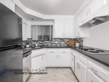 Long Beach apartment for rent - A kitchen with white cabinets and a black refrigerator.