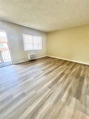 La Habra apartment for rent - A room with wooden flooring and a window with blinds.