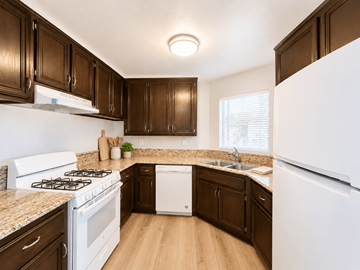 Long Beach apartment for rent - A kitchen with white appliances and brown cabinets.
