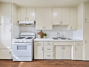 Wilmington apartment for rent - A white kitchen with a stove, sink, and cabinets.