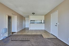 Long Beach apartment for rent - A spacious room with a carpeted floor and a white ceiling.