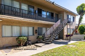 Anaheim apartment for rent - A building with a balcony and stairs leading to the entrance.