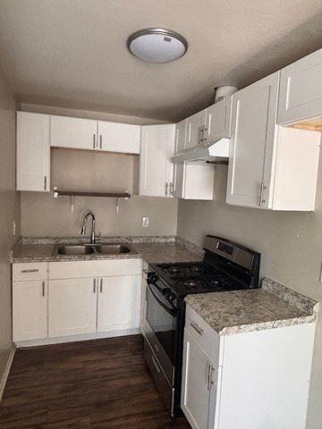 Anaheim apartment for rent - A kitchen with white cabinets and a granite counter top.