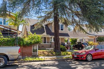 Los Angeles apartment for rent - A red car is parked on the street in front of a house.
