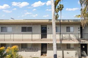Gardena apartment for rent - A building with a balcony and a palm tree in front of it.