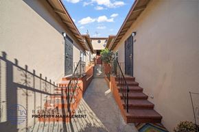 Monterey Park apartment for rent - A staircase with a metal railing and steps leading up to a door with a black gate.