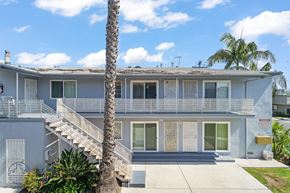 Gardena apartment for rent - A two-story house with a balcony and a palm tree in front.