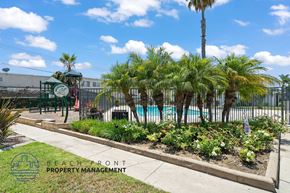 Stanton apartment for rent - A pool area with a fence and a sign that says Beachfront Property Management.