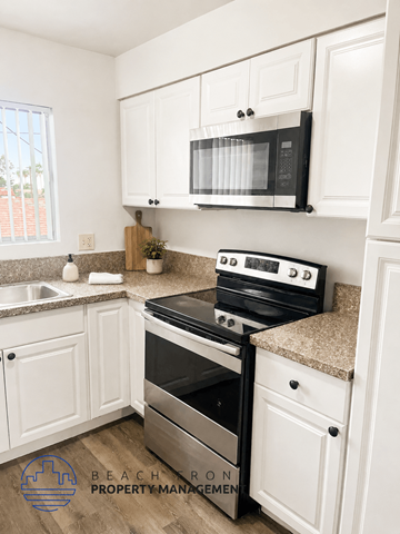 Long Beach apartment for rent - A kitchen with a stove top oven and microwave above it.