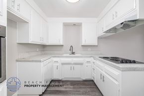 Long Beach apartment for rent - A kitchen with white cabinets and a marble countertop.