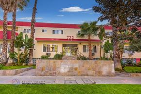Los Angeles apartment for rent - a building with palm trees and a fountain in front of it