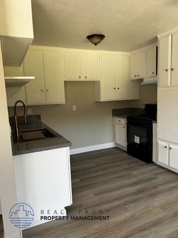 Garden Grove apartment for rent - A kitchen with white cabinets and a black oven.