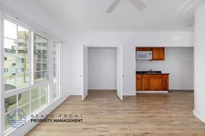 Los Angeles apartment for rent - A spacious room with wooden flooring and a kitchen area with a microwave and oven.