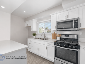 Hawthorne apartment for rent - A kitchen with white cabinets and a stove top oven.