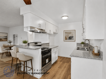 Long Beach apartment for rent - A modern kitchen with white cabinets and a marble countertop.