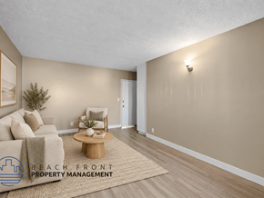 Hawthorne apartment for rent - A living room with a couch, coffee table, and a rug with the logo of Beach Front Property Management.