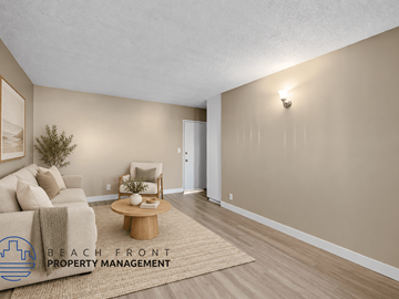 Hawthorne apartment for rent - A living room with a couch, coffee table, and a rug with the logo of Beach Front Property Management.