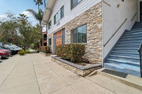 Long Beach apartment for rent - A house with a stone wall and a staircase leading to the entrance.
